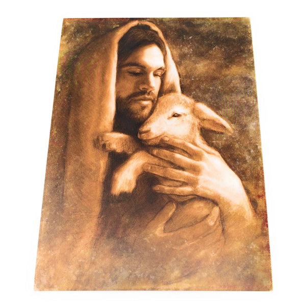A print featuring an artistic depiction of Jesus in a white robe holding a lamb.